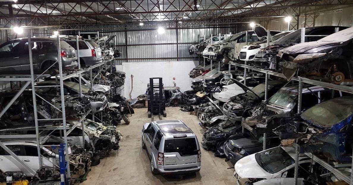 Galpão organizado com veículos e peças